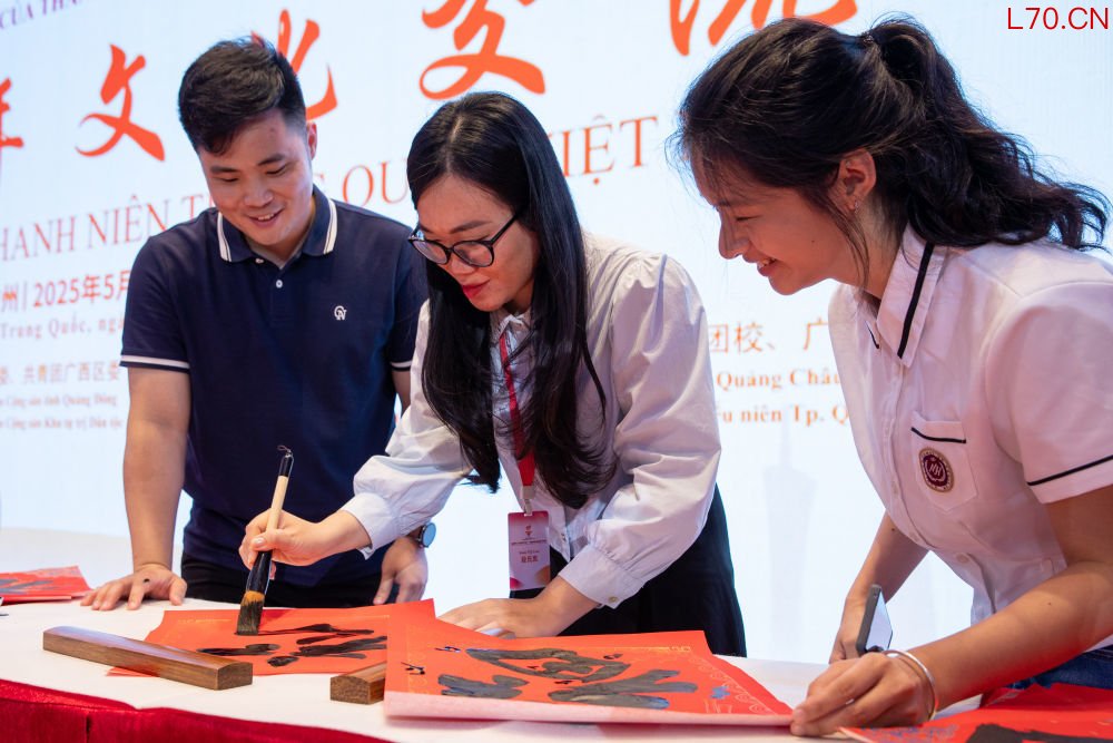 2025年5月21日，参加“红色研学之旅”的越南青年在广州举行的文化交流活动上学习中国书法。新华社记者 李旭伦 摄
